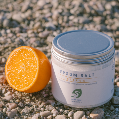 magnesium epsom salts on the beach with rocks and a orange slice lifestyle photo epsom salt bath salt crystals