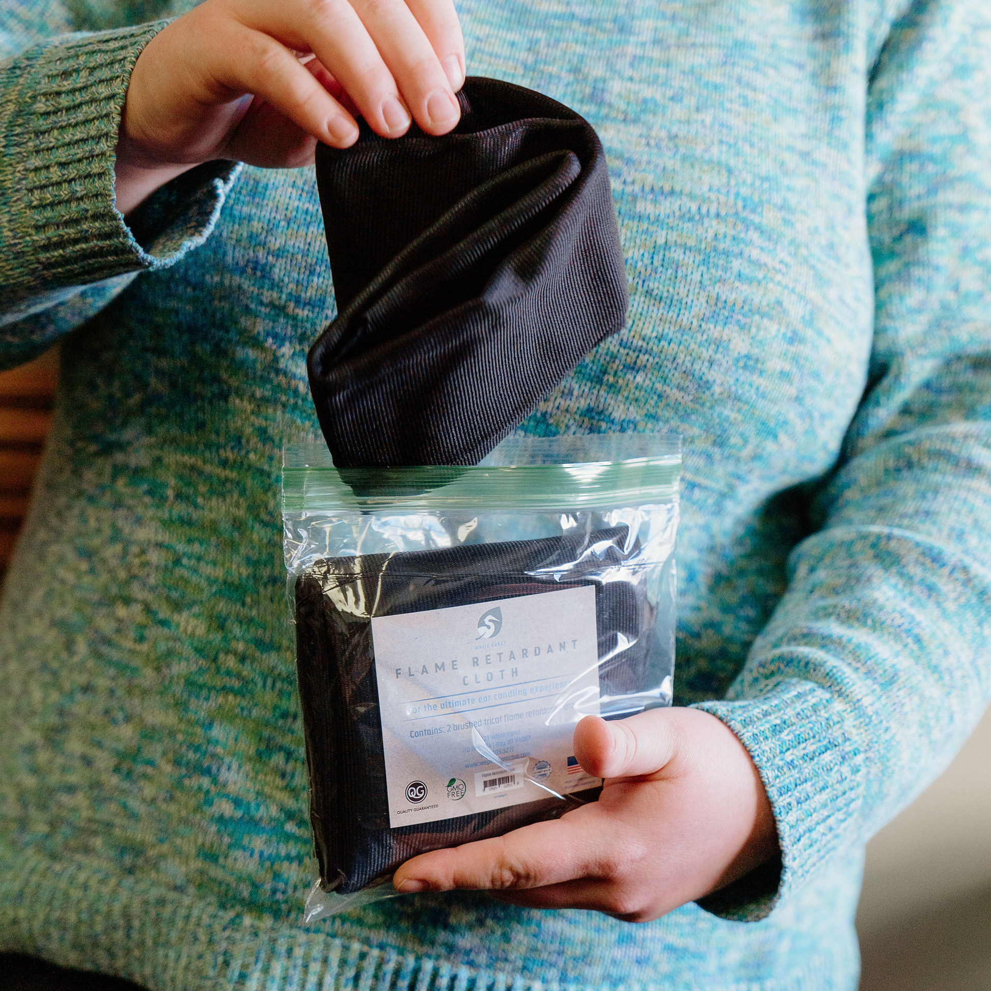 Person taking White Egret Flame Retardant Cloth out of the bag