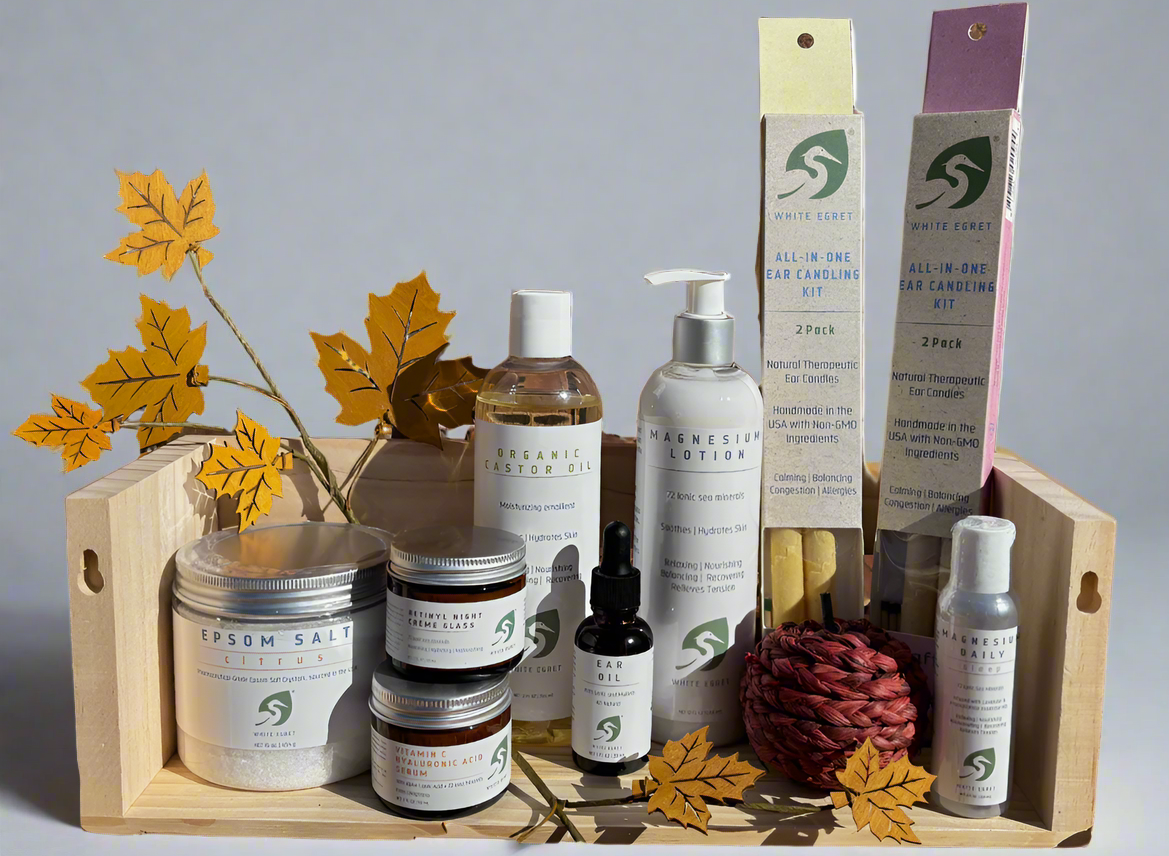 Collection of natural skincare products in a wooden box with decorative elements on a white background