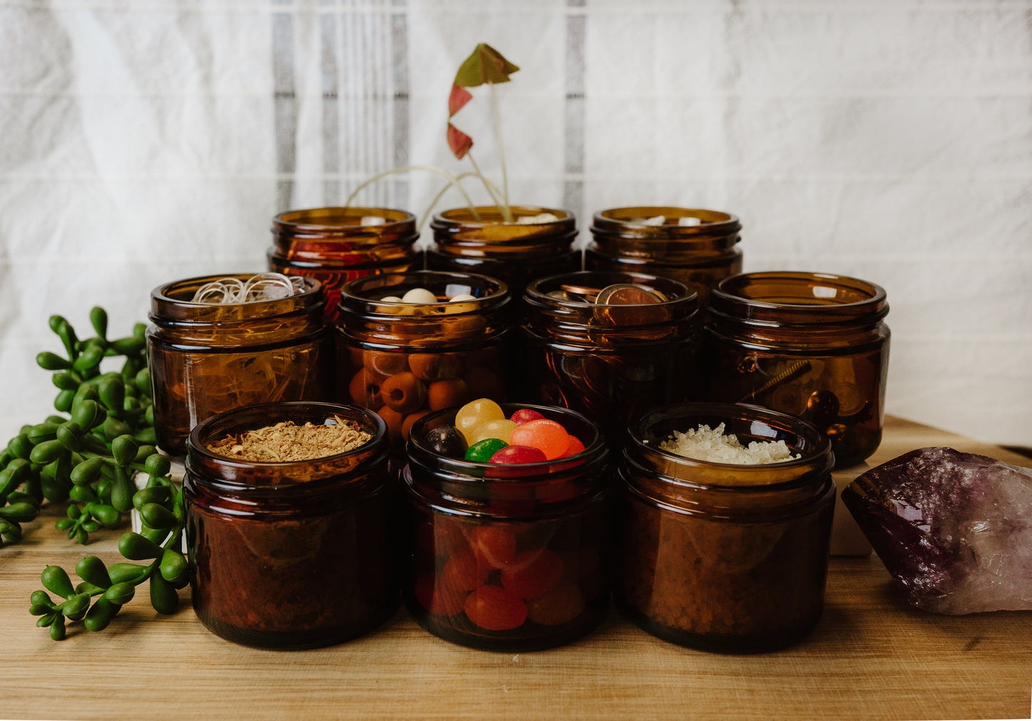 Collection of brown glass jars with various contents on a wooden surface.