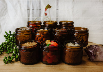 Collection of brown glass jars with various contents on a wooden surface.